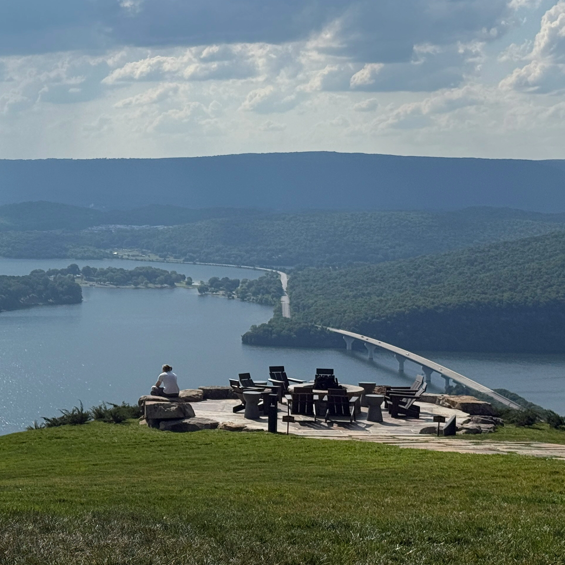 river snaking through the tennessee mountains with a man on a hill with some chairs.